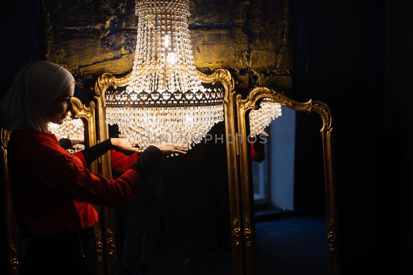Fashion muslim model near big expensive chandelier. Islamic religion. Girl near mirrors. by Rabizo