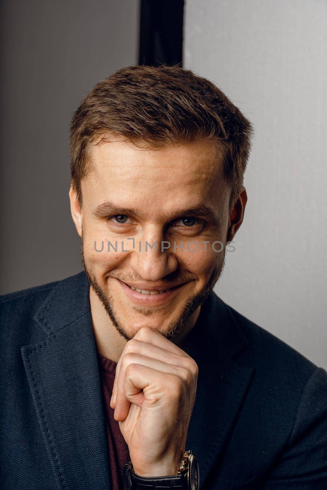 Confident male smiling. Business man portrait on dark background. Handsome young man weared suit in studio by Rabizo