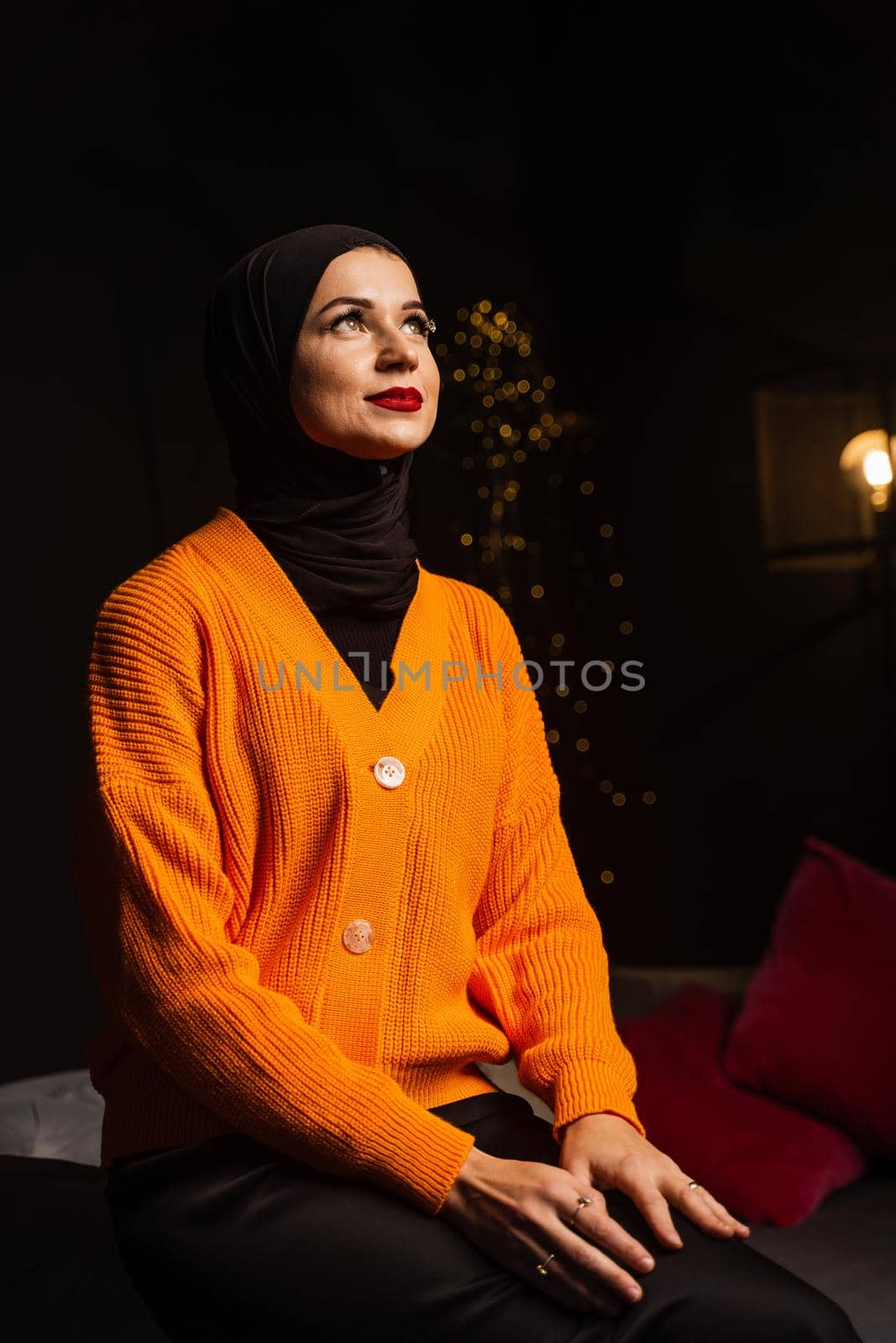 Muslim woman in black hijab near new year tree waiting for celebration of Christmas. Islam religion