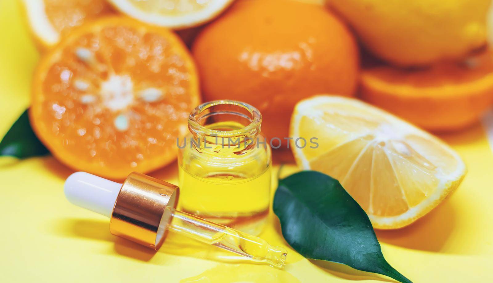 orange essential oil on a yellow background. Selective focus.nature