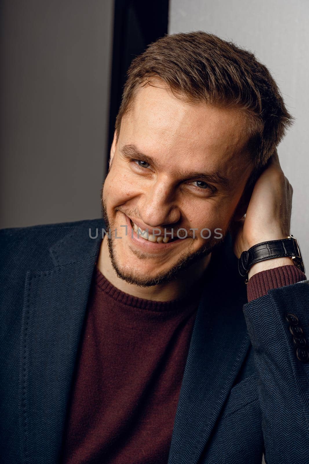 Confident male smiling. Business man portrait on dark background. Handsome young man weared suit in studio by Rabizo