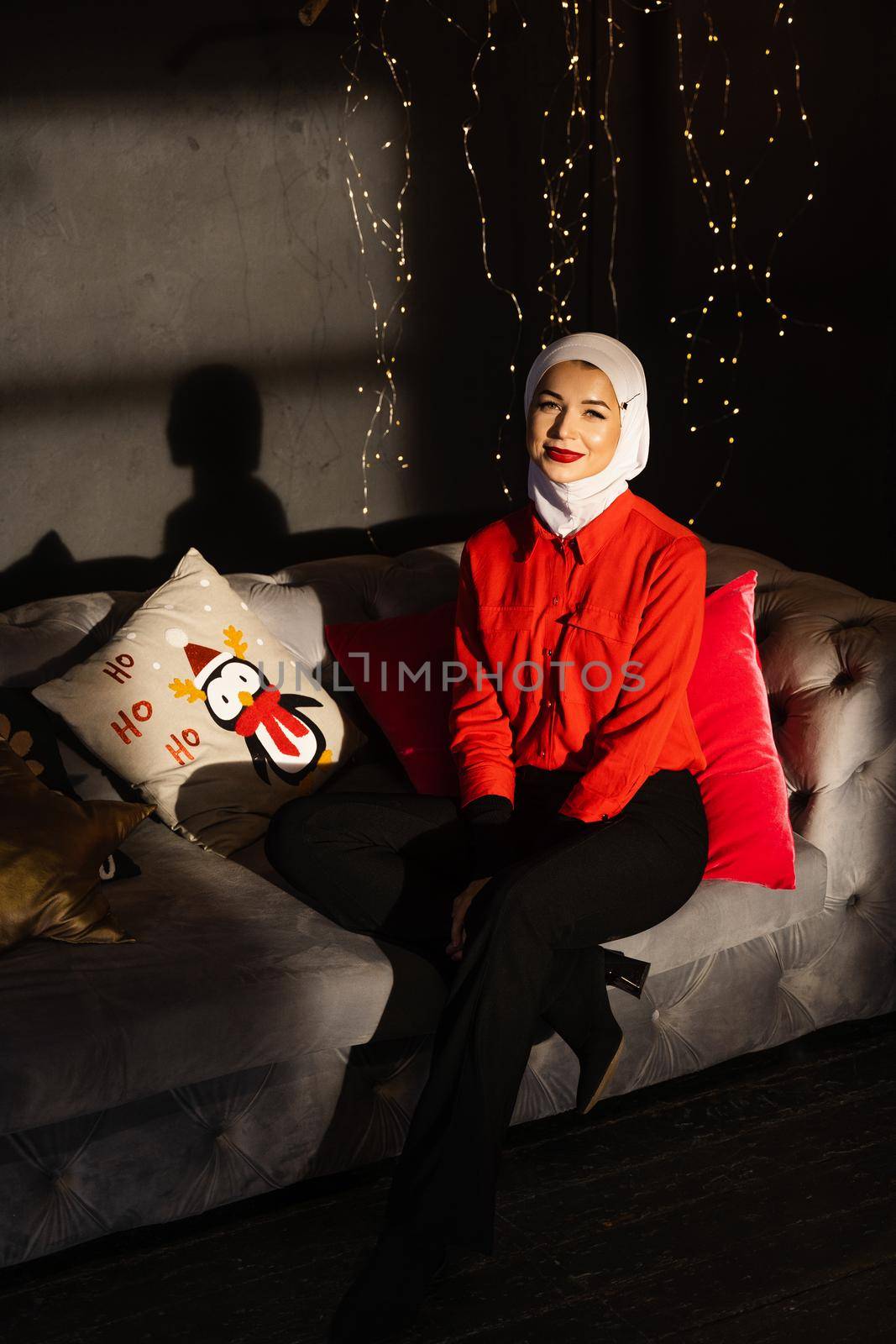 Muslim woman near christmas lights and decoration in studio. Professional muslim model posing at the new year eve.