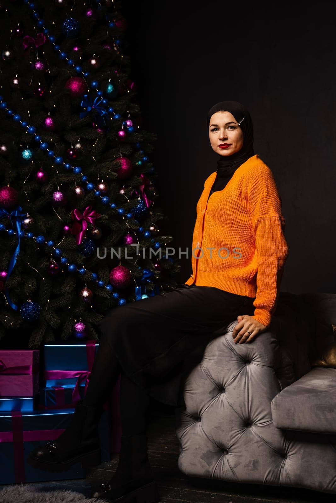 Muslim woman in black hijab near new year tree waiting for celebration of Christmas. Islam religion. by Rabizo