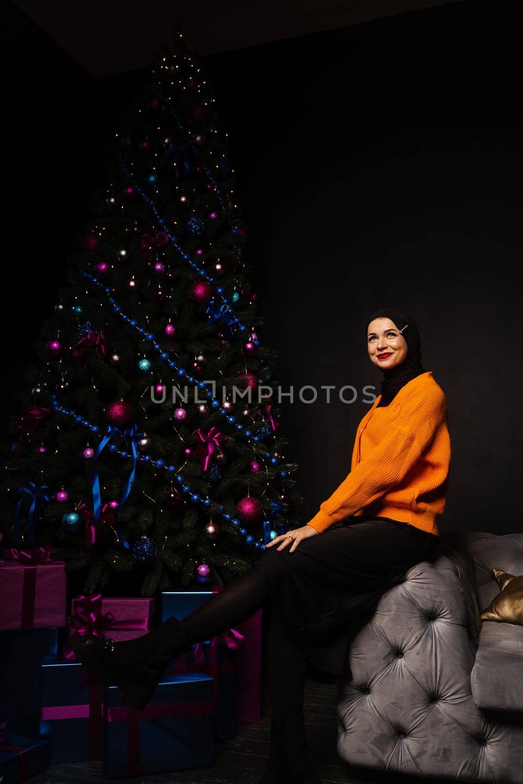 Muslim woman in black hijab near new year tree waiting for celebration of Christmas. Islam religion. by Rabizo