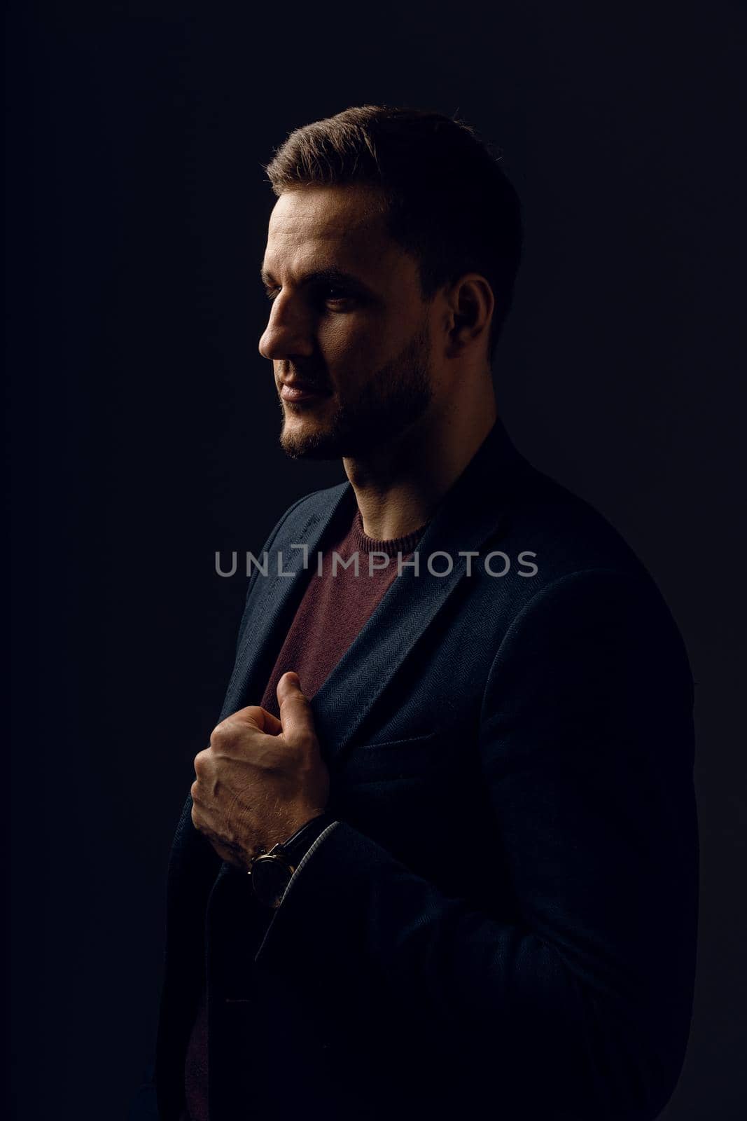 Business man portrait on dark background. Handsome young man weared suit in studio. Confident professional fashion male posing in studio by Rabizo
