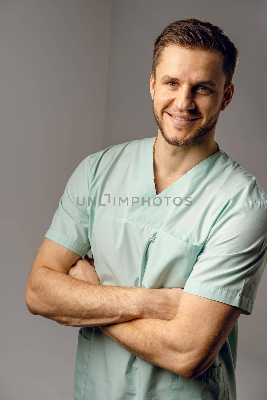 Surgeon weared in medical robe smile and posing on white background. Handsome happy doctor posing in studio. by Rabizo