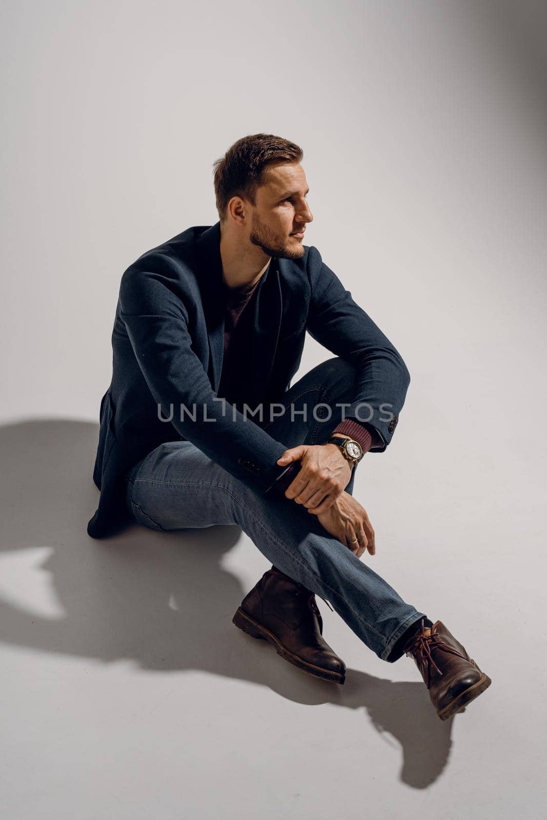 Fashion business man model posing in the studio. Confident male weared casual suit by Rabizo