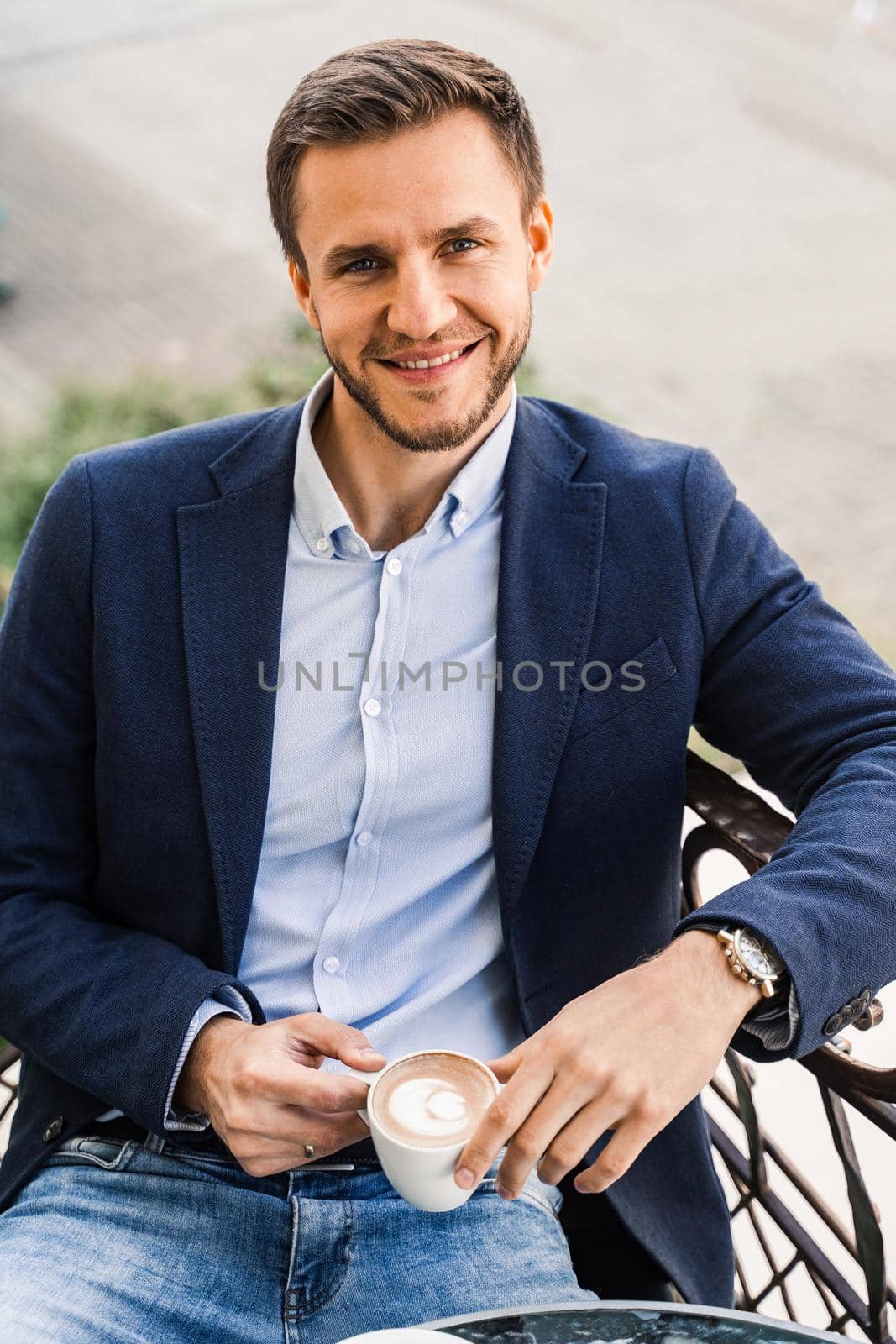 Handsome man with cup of coffee in cafe. Morning lifestyle of male. by Rabizo