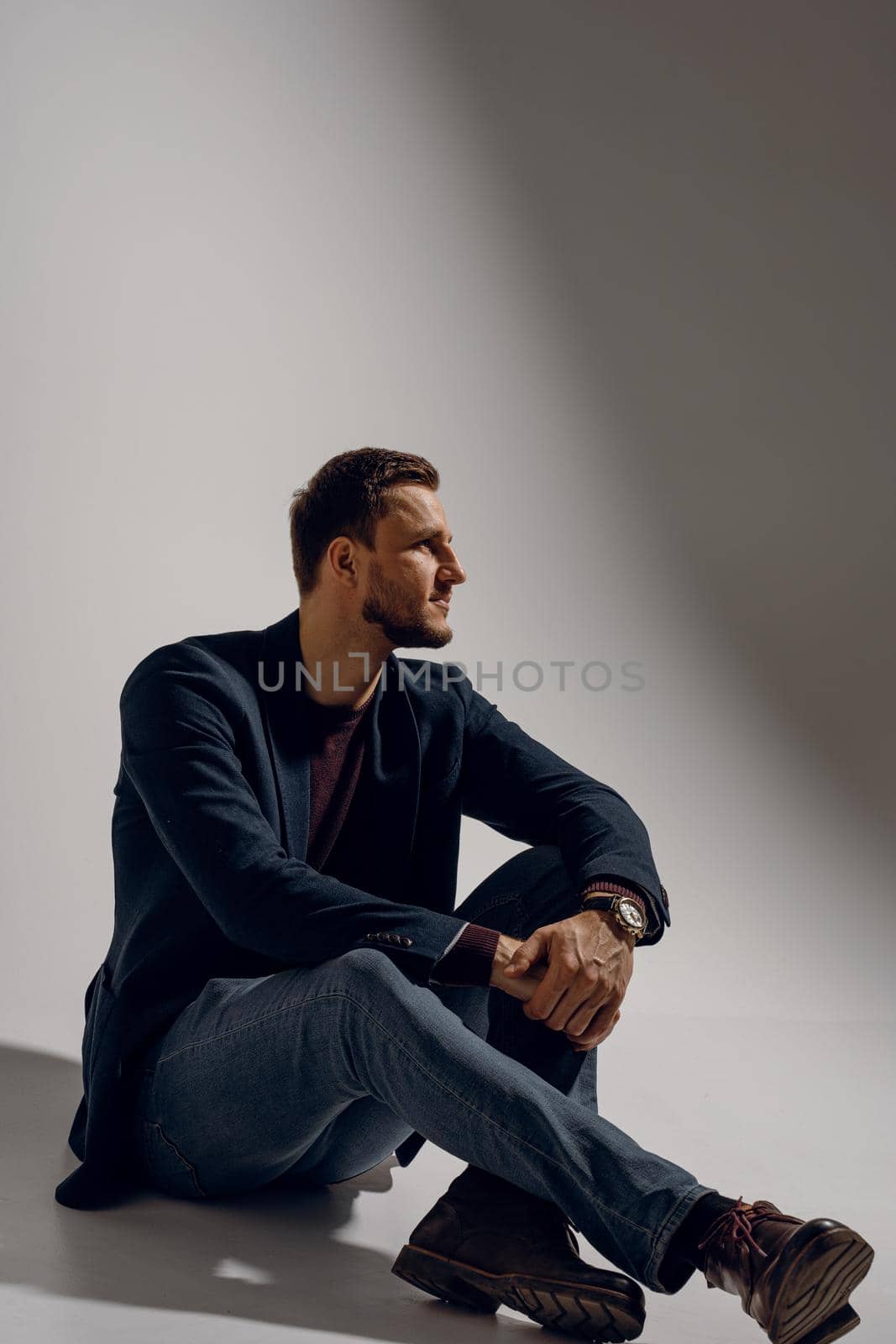 Fashion business man model posing in the studio. Confident male weared casual suit by Rabizo