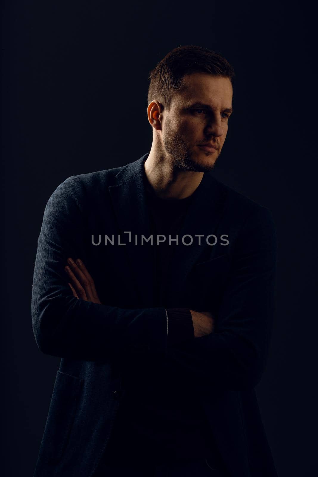 Business man portrait on dark background. Handsome young man weared suit in studio. Confident professional fashion male posing in studio.