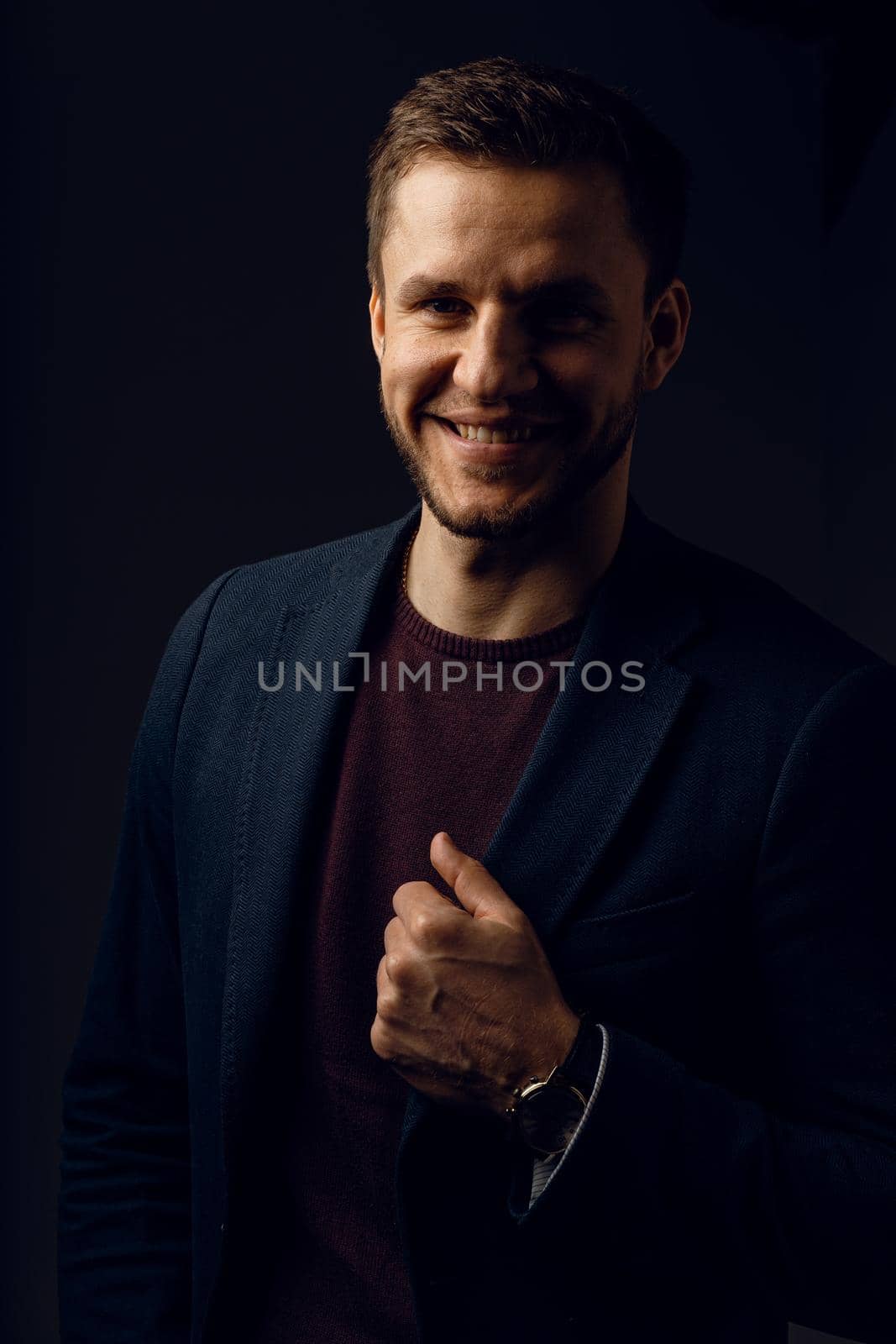 Confident professional fashion male posing in studio. Business man portrait on dark background. Handsome young man weared suit.