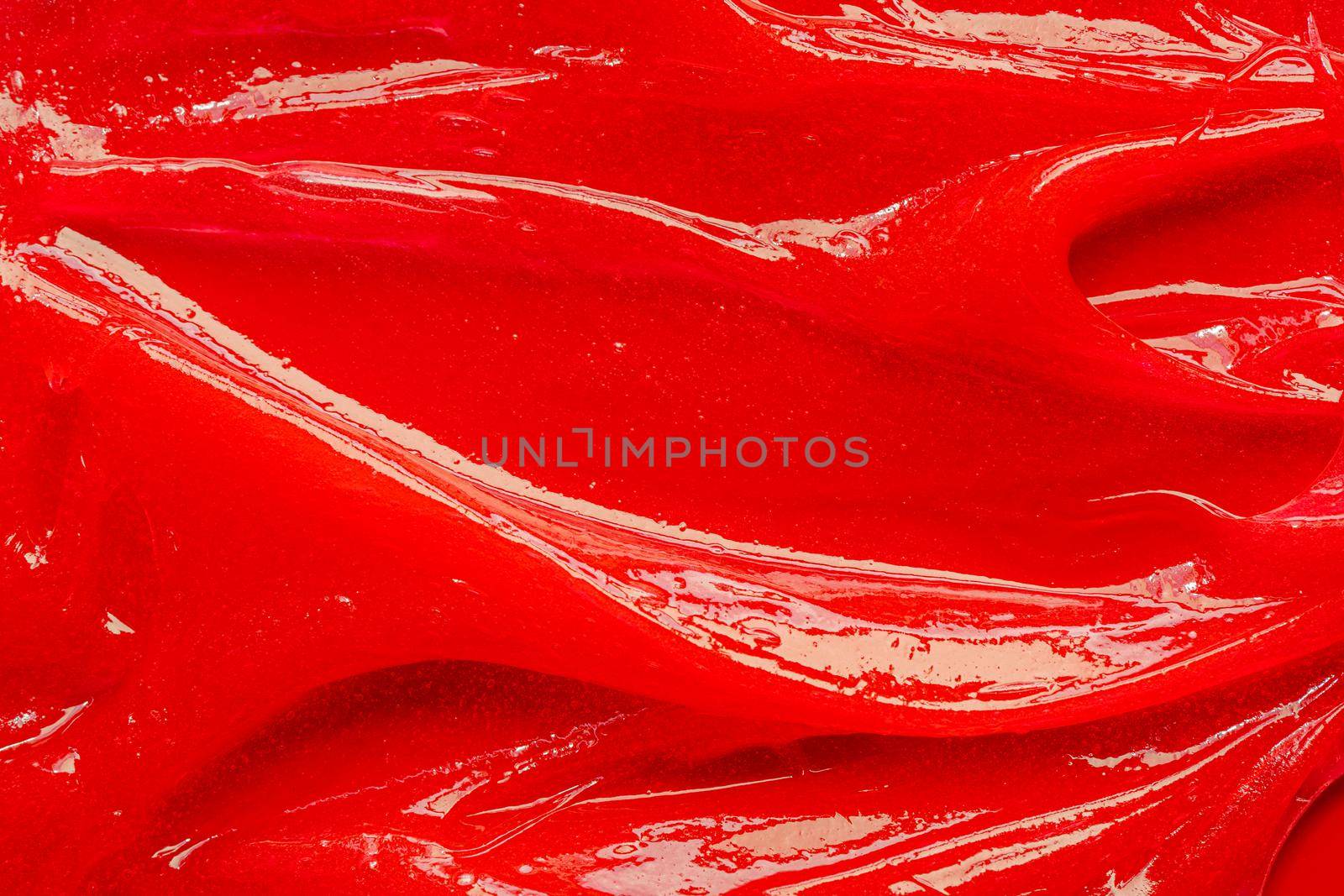 Red gel texture. Cosmetic clear liquid cream smudge. Skin care product sample closeup. Toothpaste or wax by photolime