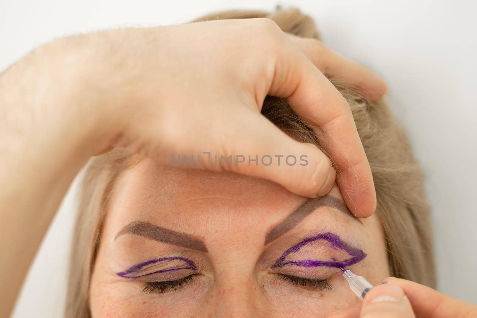 Blepharoplasty markup close-up on the face before the plastic surgery operation for modifying the eye region of the face in medical clinic. Doctor doing plastic cosmetic operation