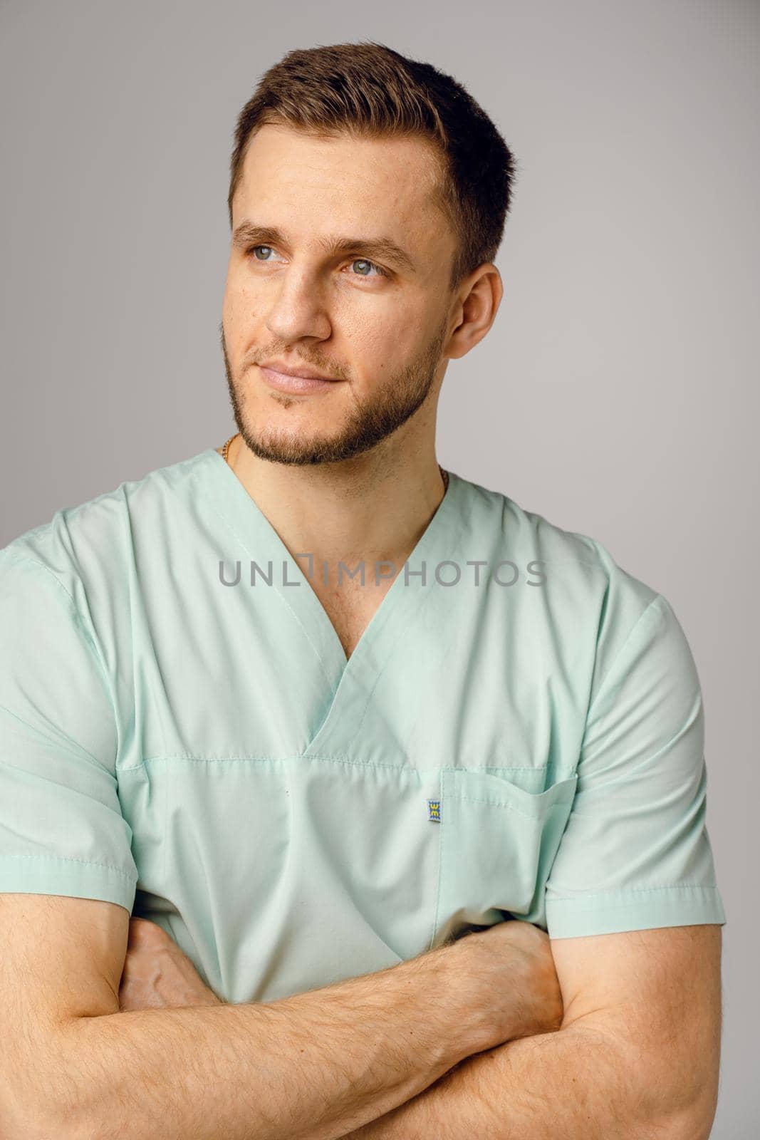 Surgeon weared in medical robe smile and posing on white background. Handsome happy doctor posing in studio