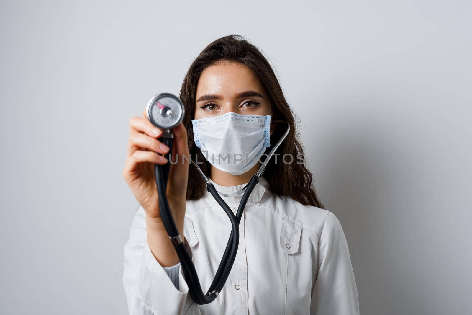 Doctor in medical mask with phonendoscope does auscultation to patient. Medical therapy and treatment. Research and testing for coronavirus covid-19