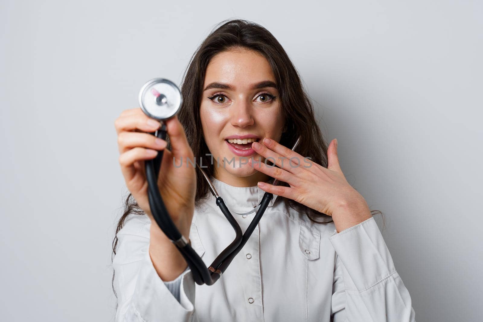 Smiley woman doctor surgeon with stethoscope on white background. Professional medecine. advert for medical clinic