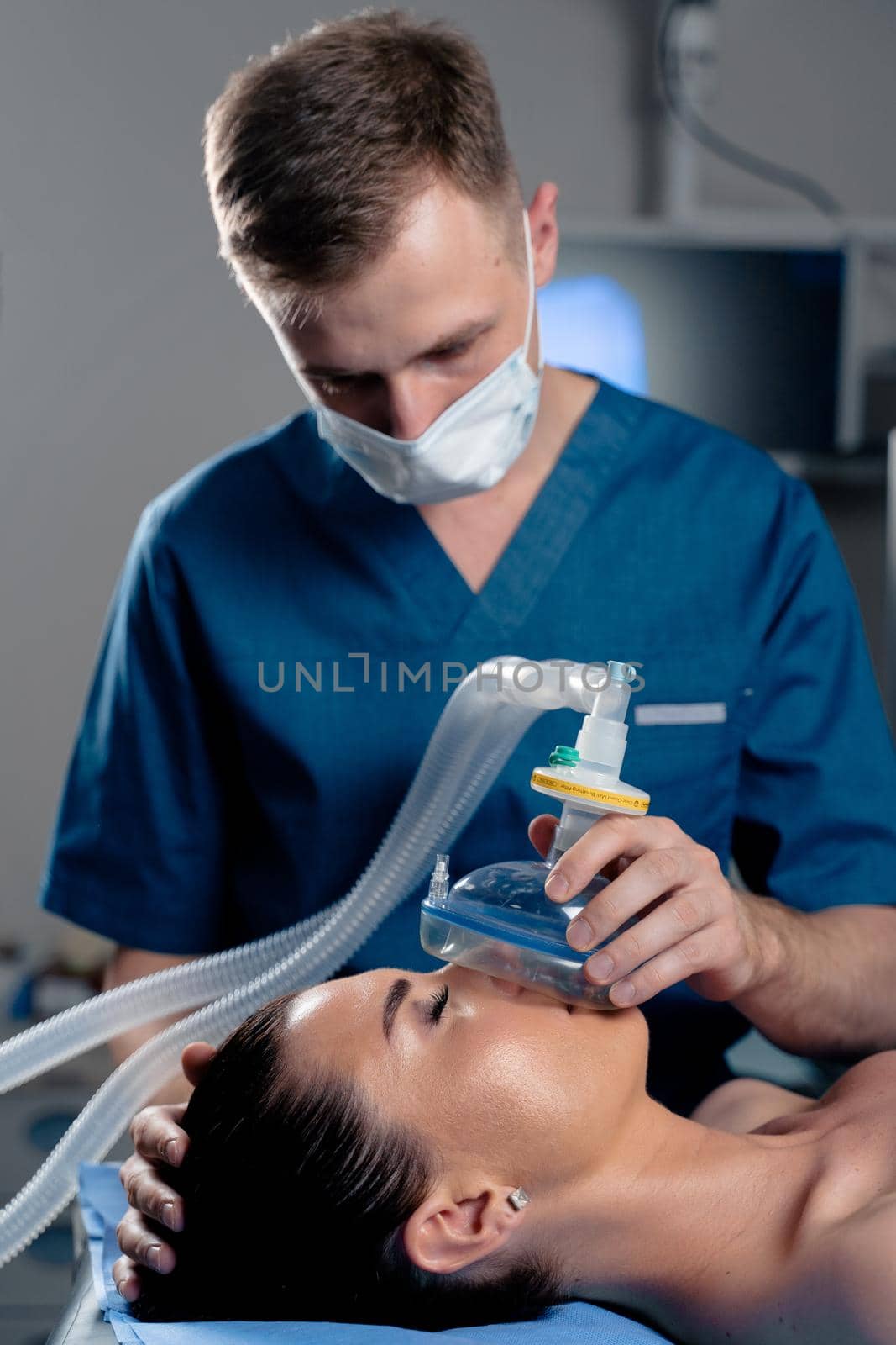 Anesthesiologist making ingalation anesthesia for patient. Doctor puts a mask on the patient before starting operation by Rabizo