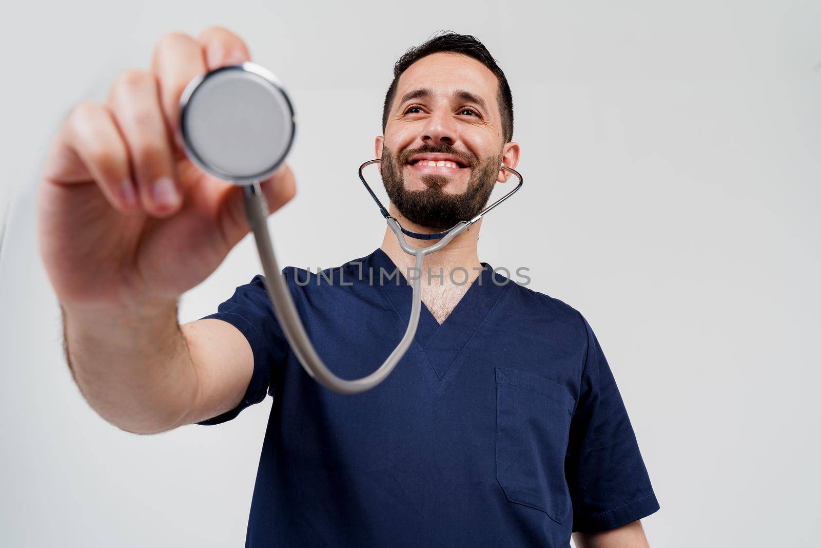 Smiley arabian doctor surgeon with stethoscope on white background. Professional arab medecine. advert for medical clinic