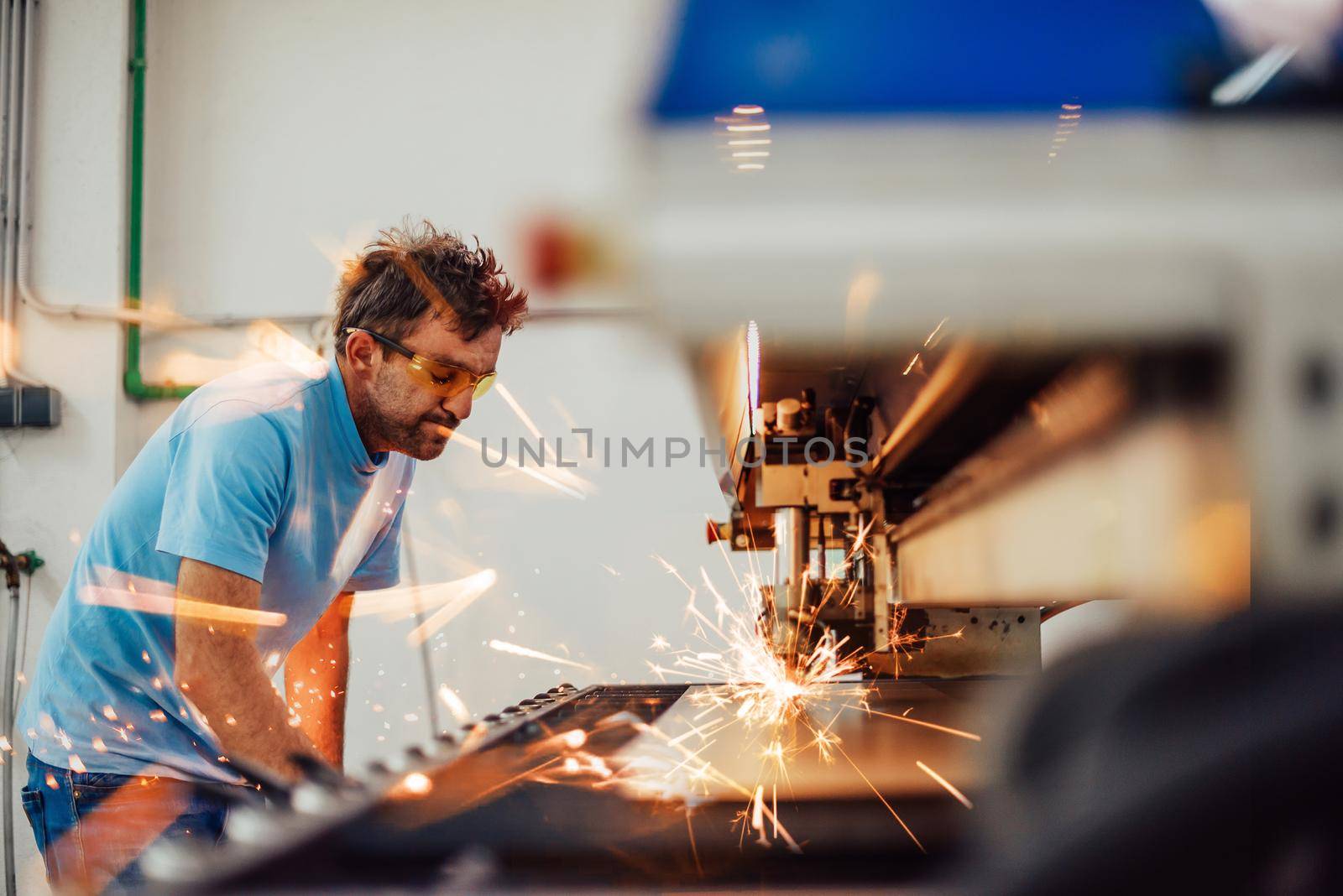 Within heavy industry. A man works in a modern factory on a CNC machine. Selective focus. High-quality photo