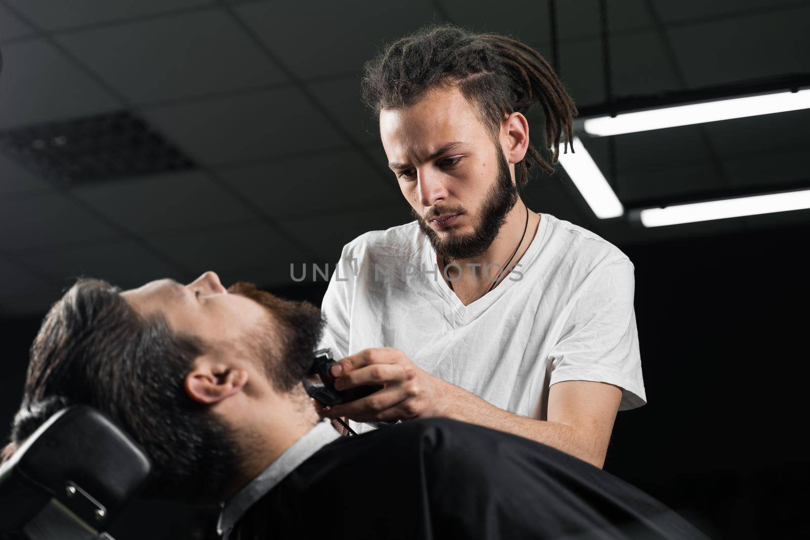 Trimming the beard with a shaving machine. Advertising for barbershop and men's beauty salon.