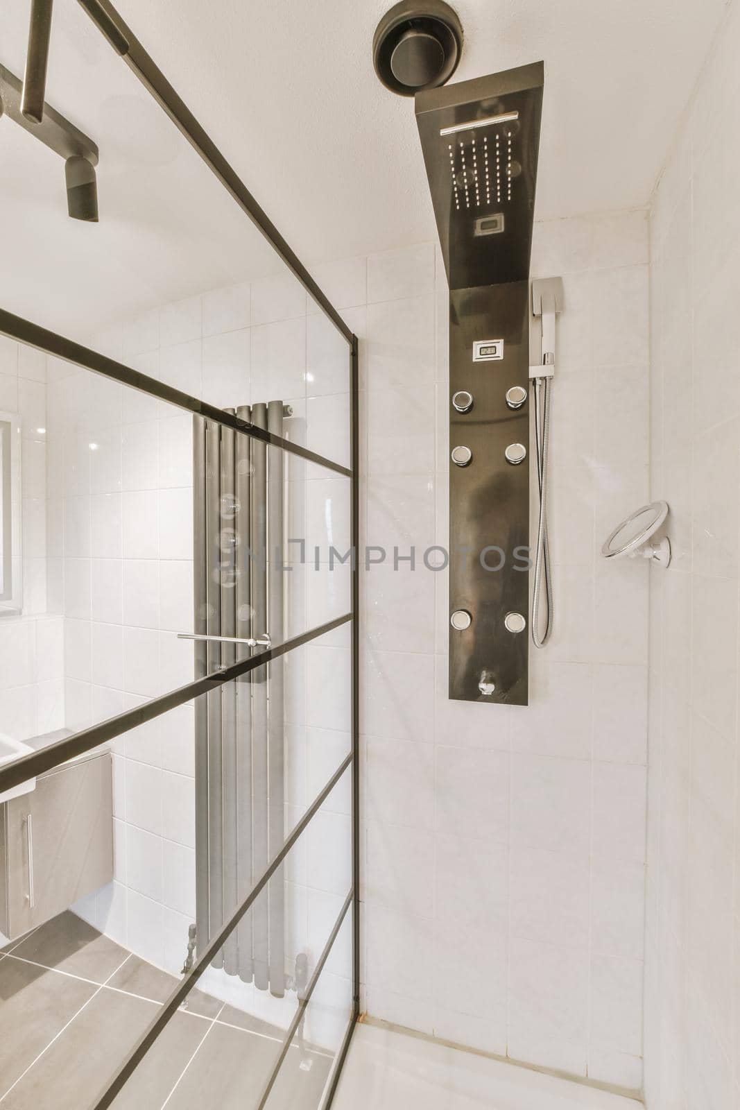 The interior of a modern bathroom with a glazed shower cabin by casamedia