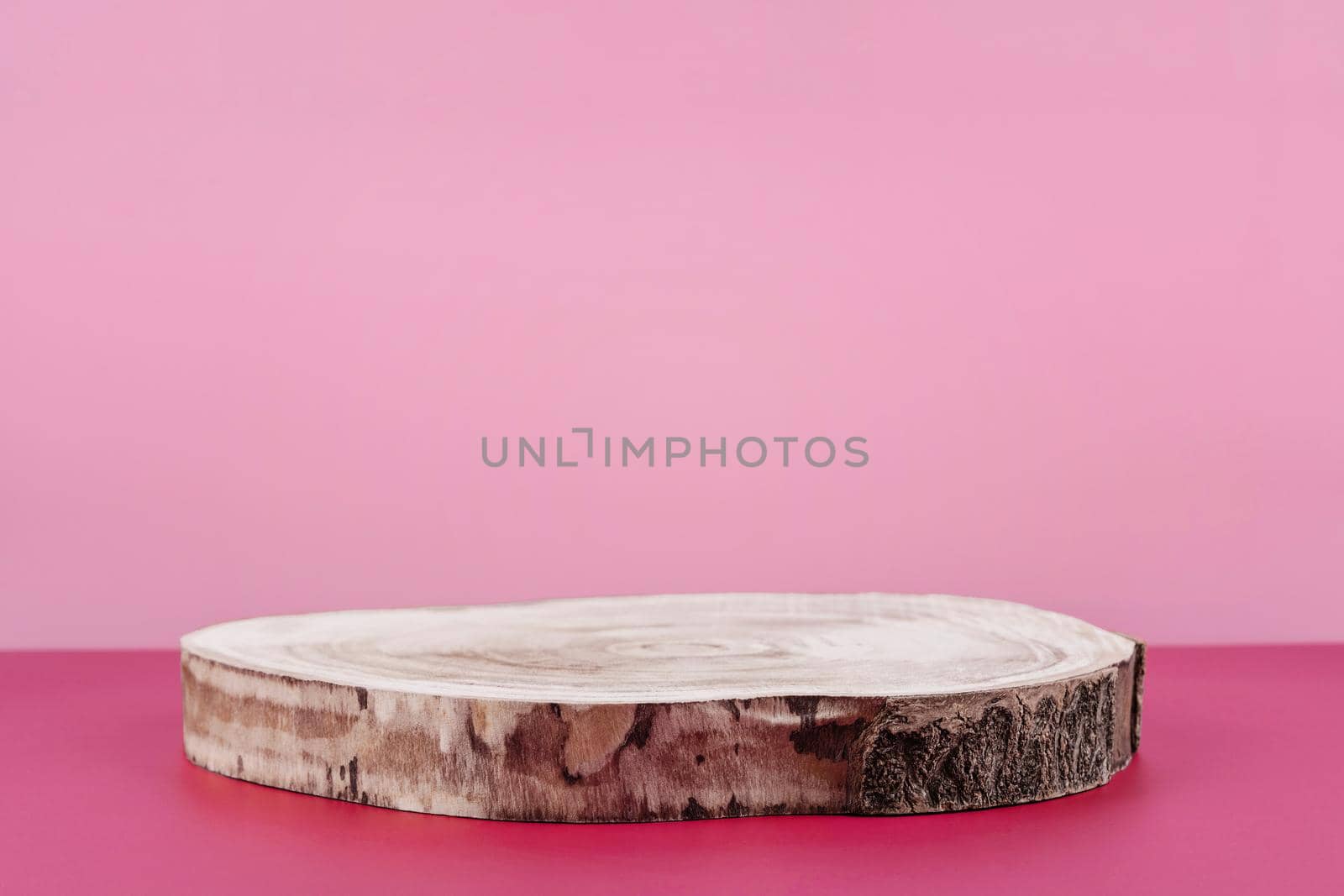 Background for cosmetic product presentation, wooden podium showcase on pink background for cosmetics perfume and jewellery minimalist display. Empty stage pedestal for beauty products. Front view