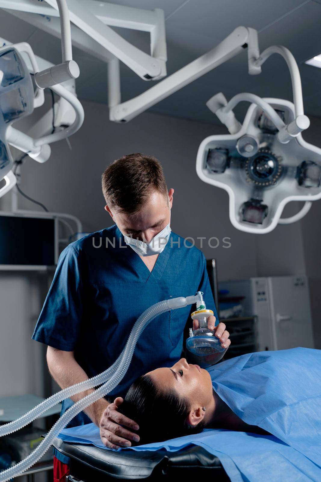 The doctor puts on a mask for artificial ventilation of the lungs in the intensive care unit.