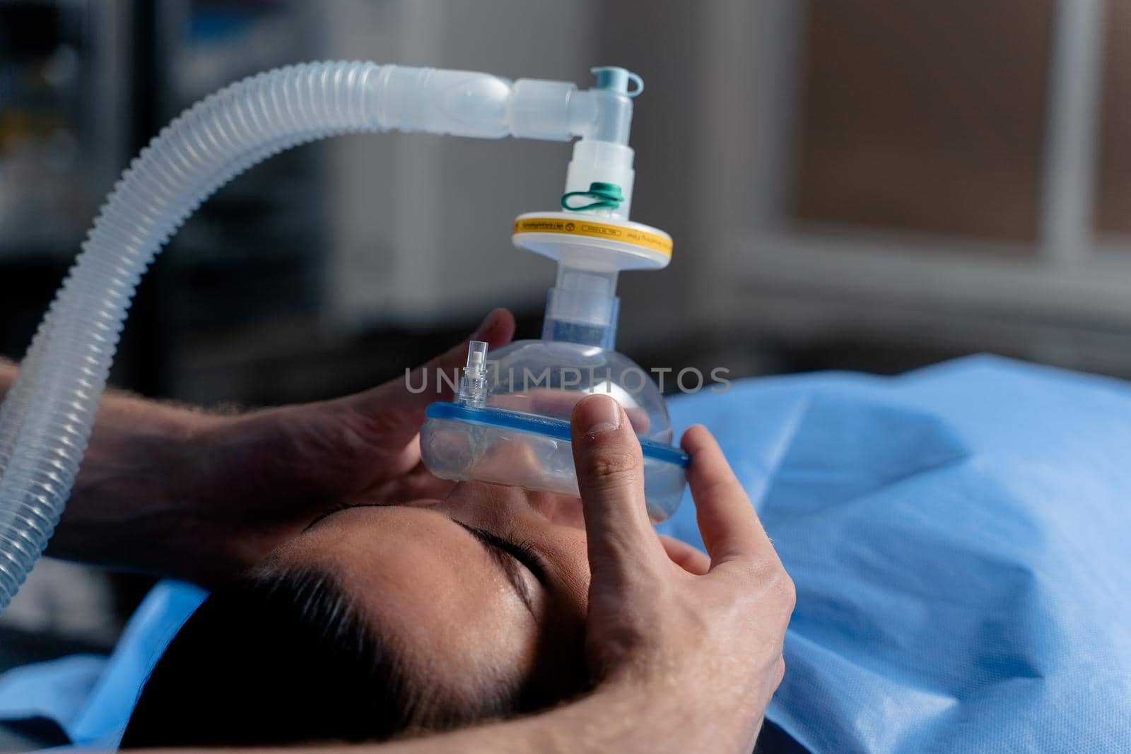 Treatment of a severe form of coronovirus covid-19. The doctor puts on a mask for artificial ventilation of the lungs in the intensive care unit.