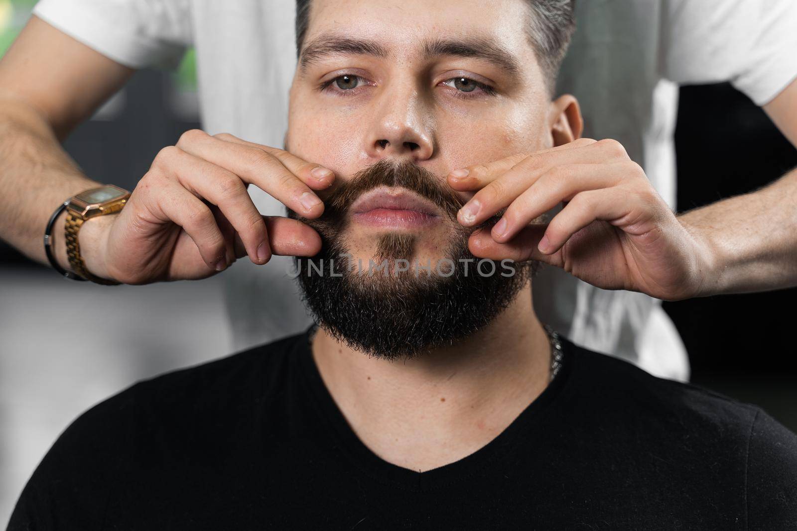 Fixing the shape of mustache with wax. The result of a haircut in a barbershop