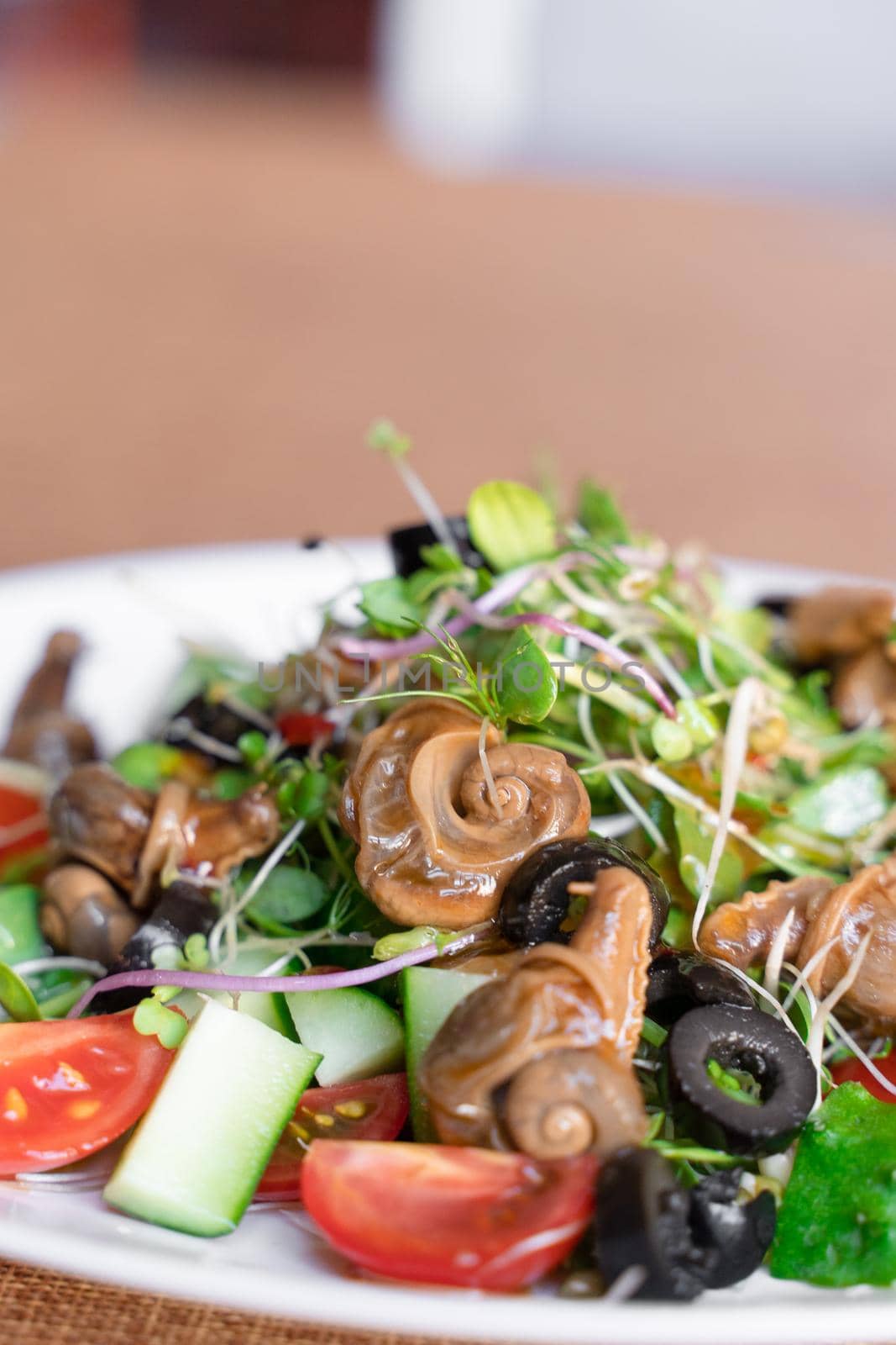 Salad with snail, olive, tomatoe cherie, cucumber and greens.