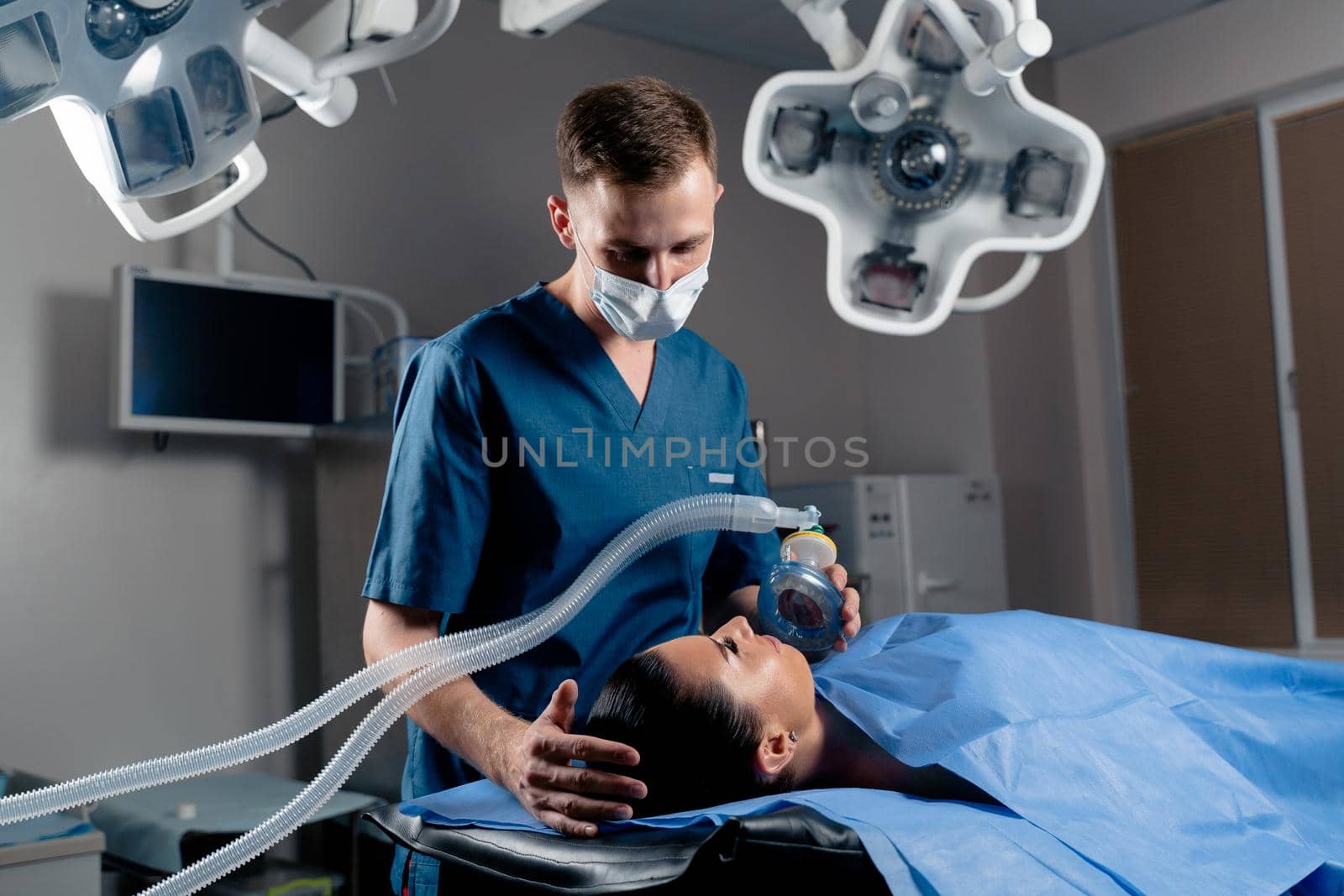 Anesthesiologist making ingalation anesthesia for patient. Doctor puts a mask on the patient before starting operation by Rabizo