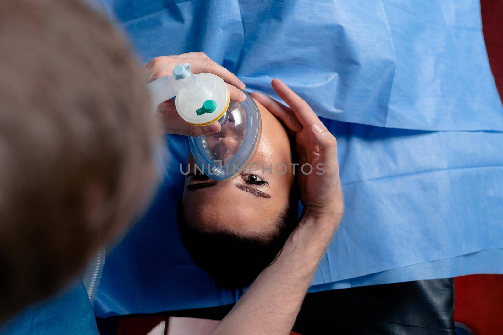 The doctor puts on a mask for artificial ventilation of the lungs in the intensive care unit by Rabizo