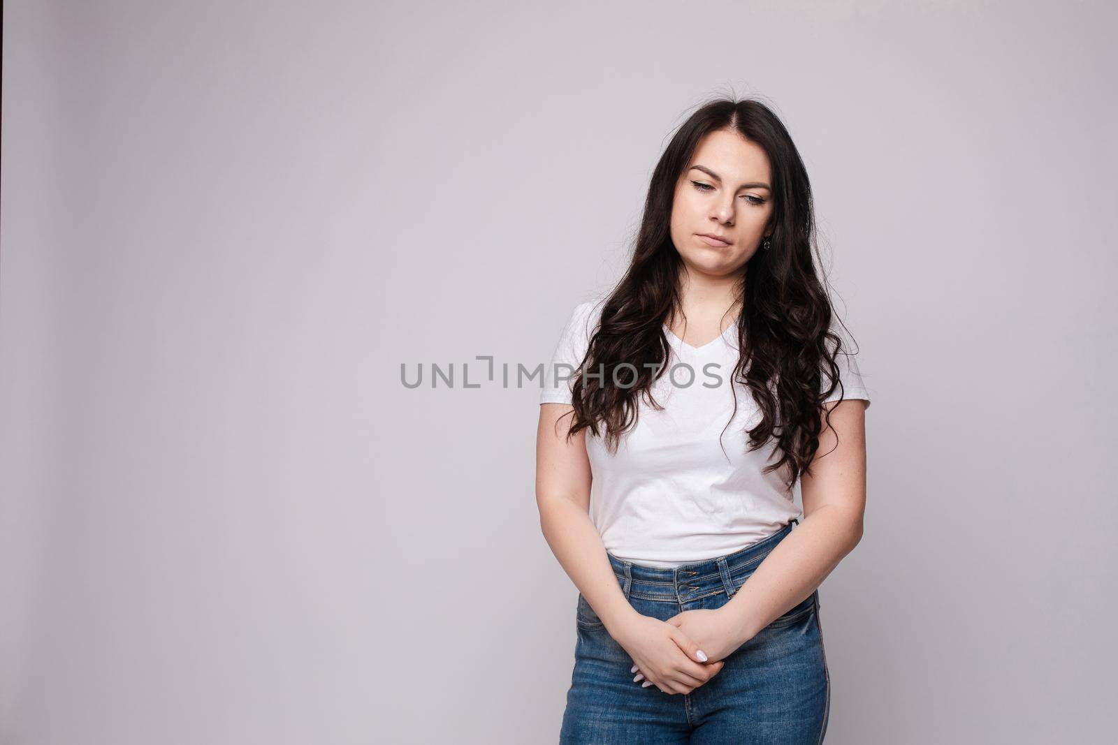 Upset young beautiful woman standing with crossed hands isolated at white studio background by StudioLucky