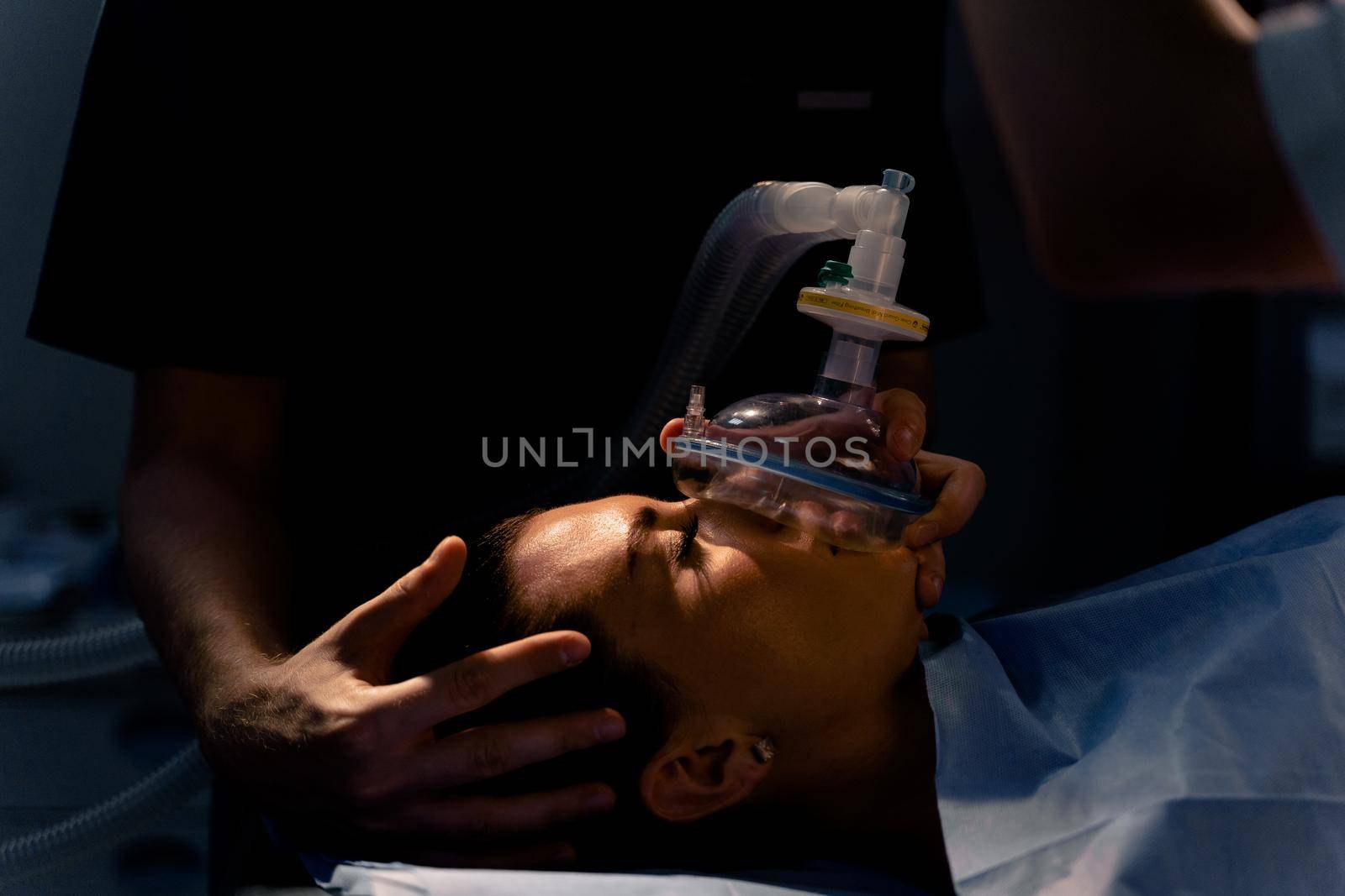 The doctor puts on a mask for artificial ventilation of the lungs in the intensive care unit by Rabizo