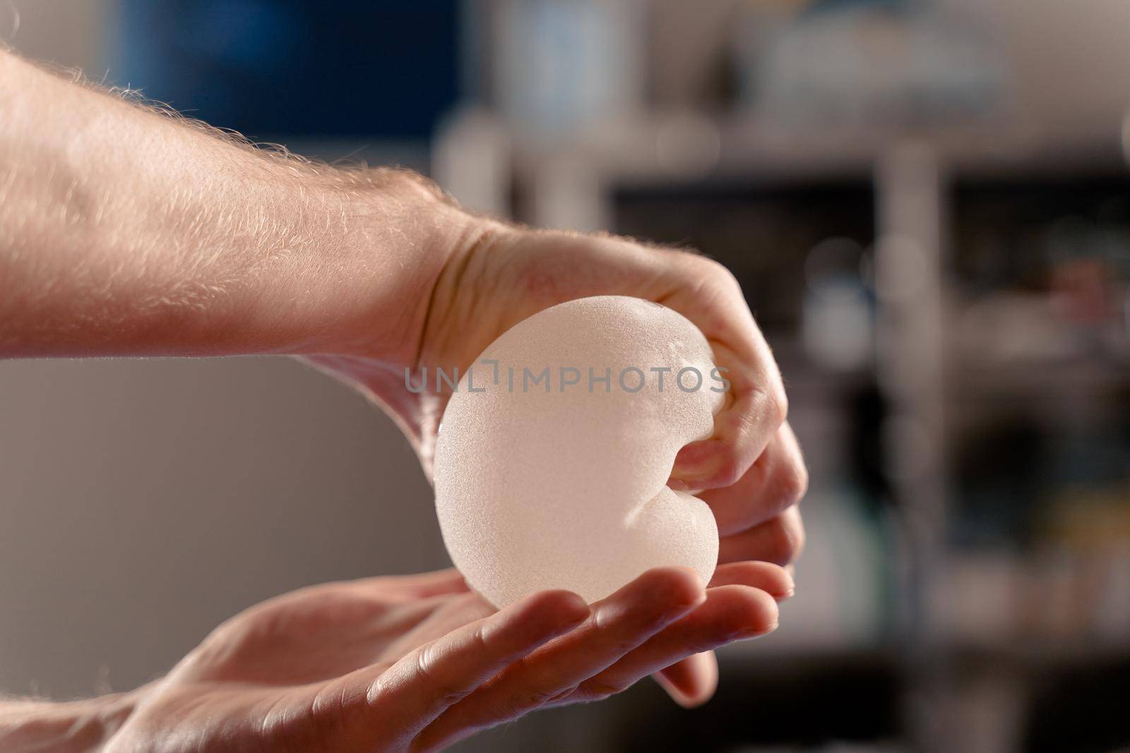 The surgeon touches and squeezes the silicone implants for quality control. Breast augmentation and lift surgery.
