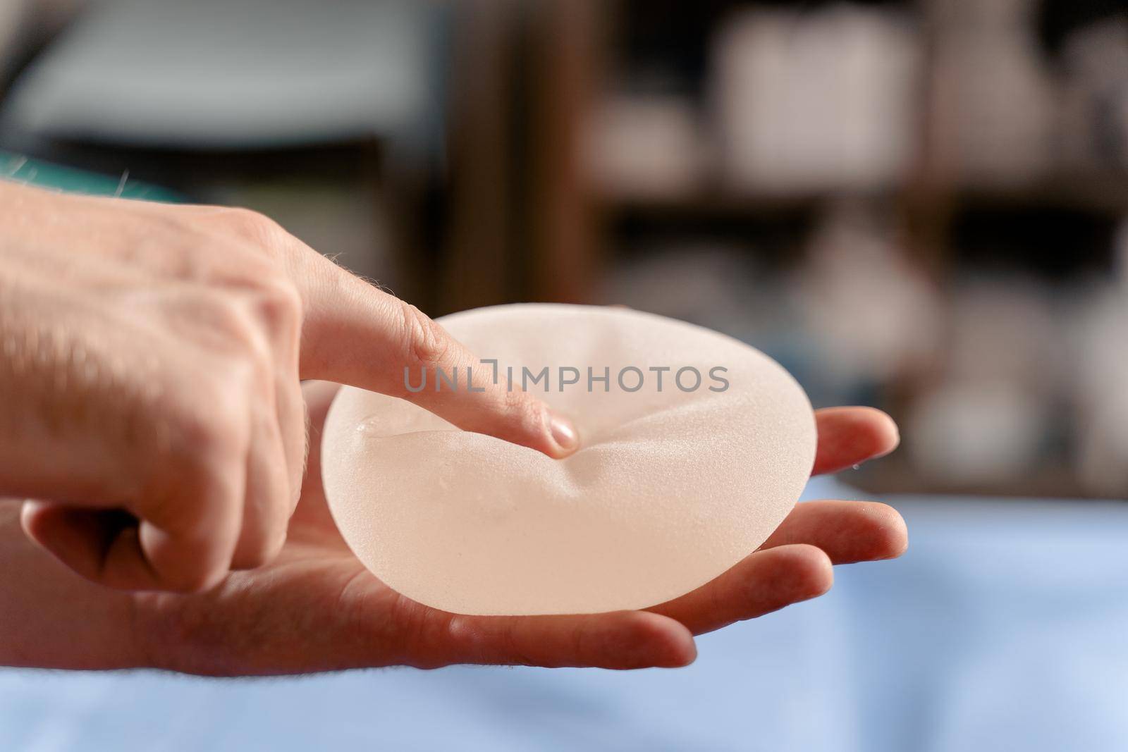 Silicone implant in hand close-up. Breast augmentation and lift surgery by Rabizo