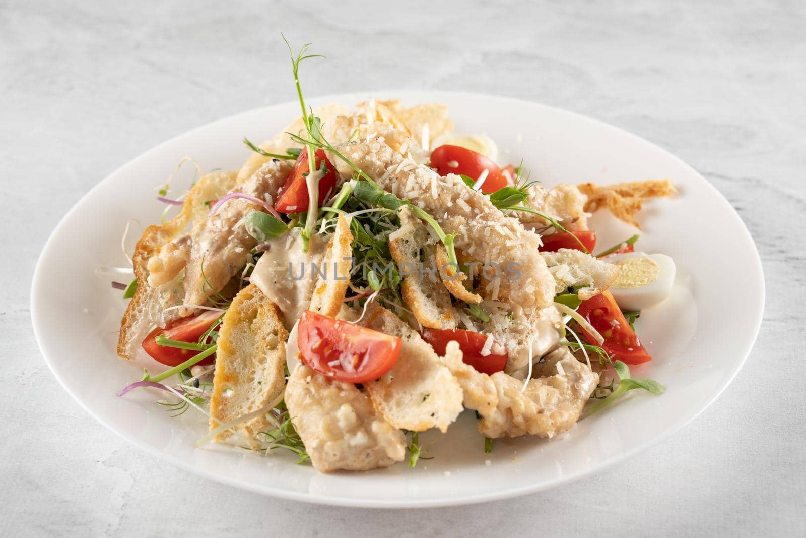 Caesar salad with chicken and parmesan, cherry tomato, lettuce, croutons and egg,