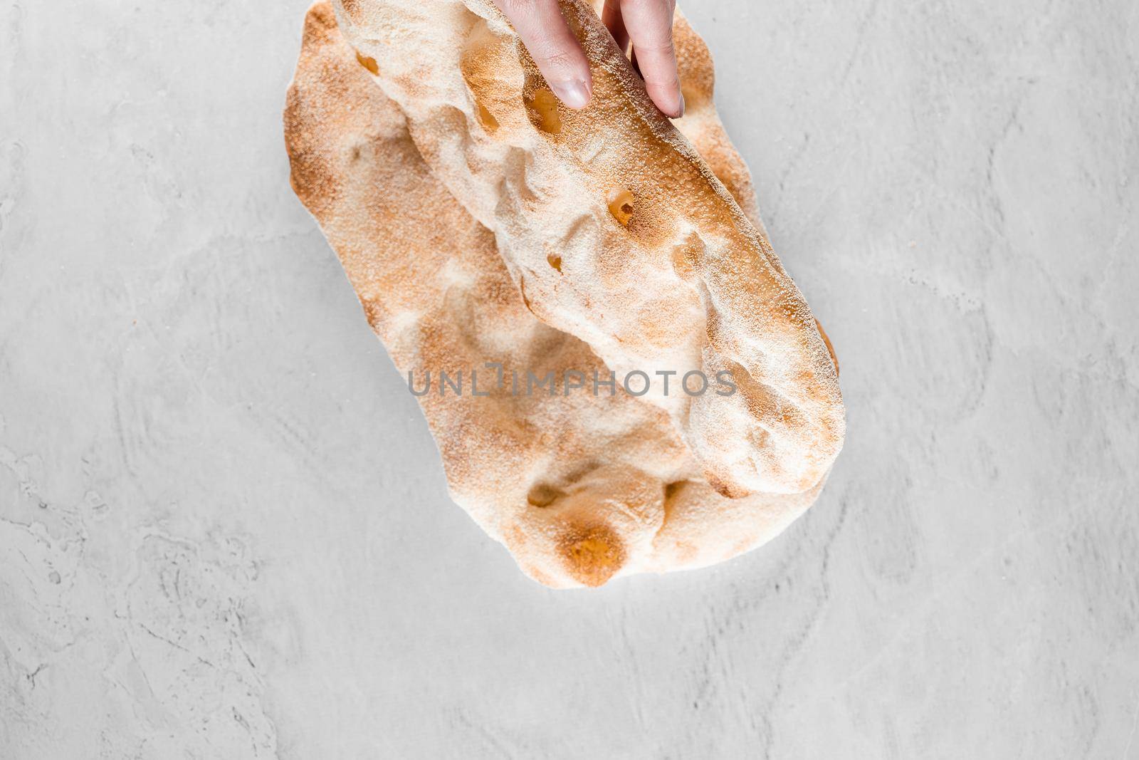 Touching and checking quality dough for pinsa romana on light background. Gourmet italian cuisine