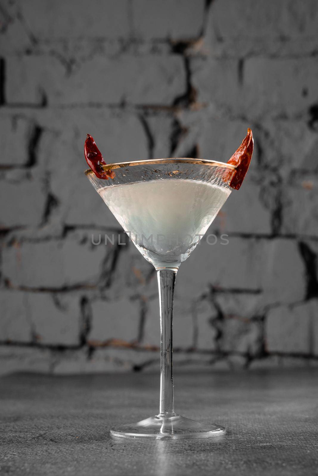 Cocktail in glass with chili on gray background. Devil alcohol drink. by Rabizo