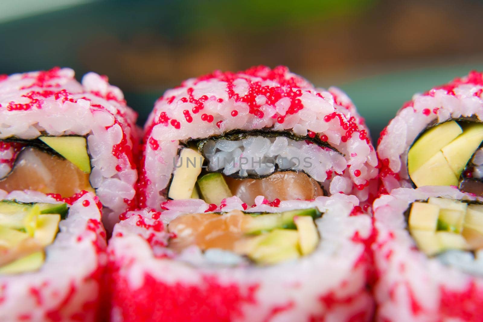 California rolls with caviar, salmon and avocado, cucumber, nori close-up