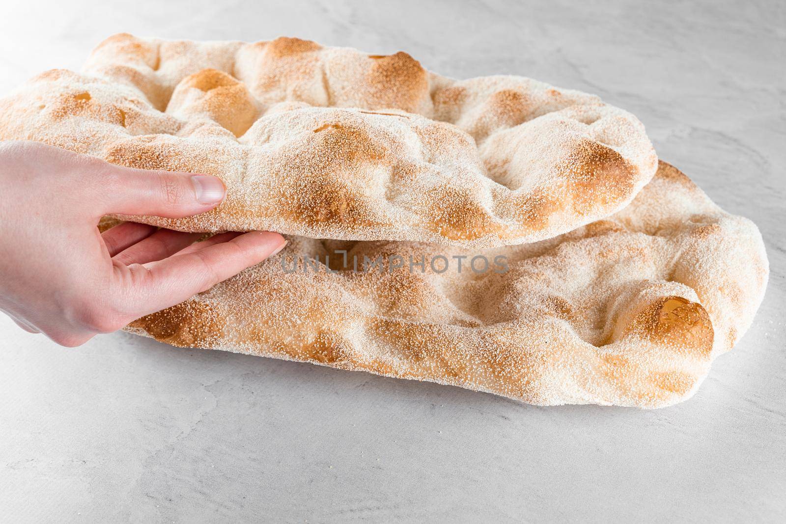 Touching and checking quality dough for pinsa romana on light background. Gourmet italian cuisine. by Rabizo