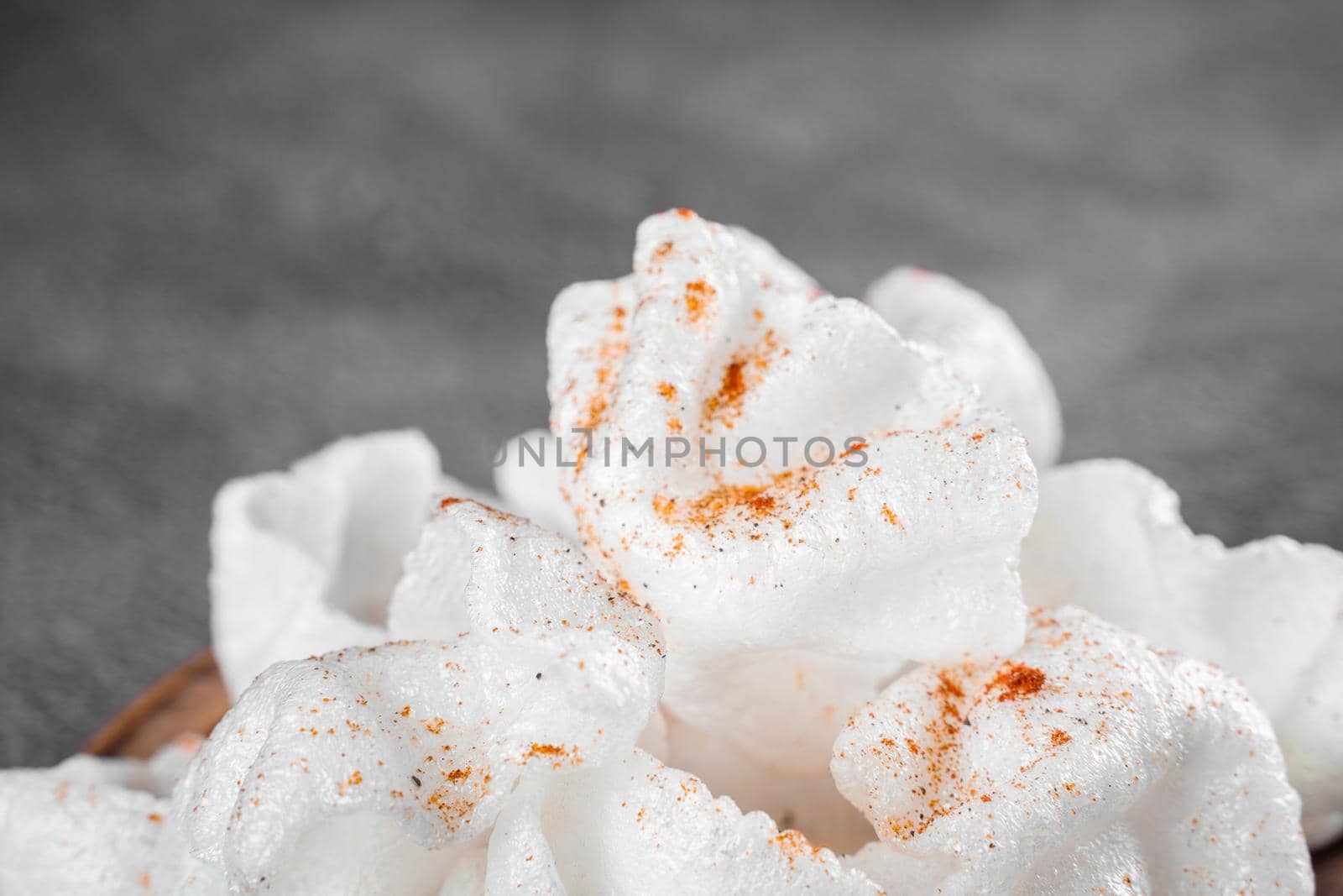 Rice paper chips fried in oil. Rice chips on a wooden board on gray background