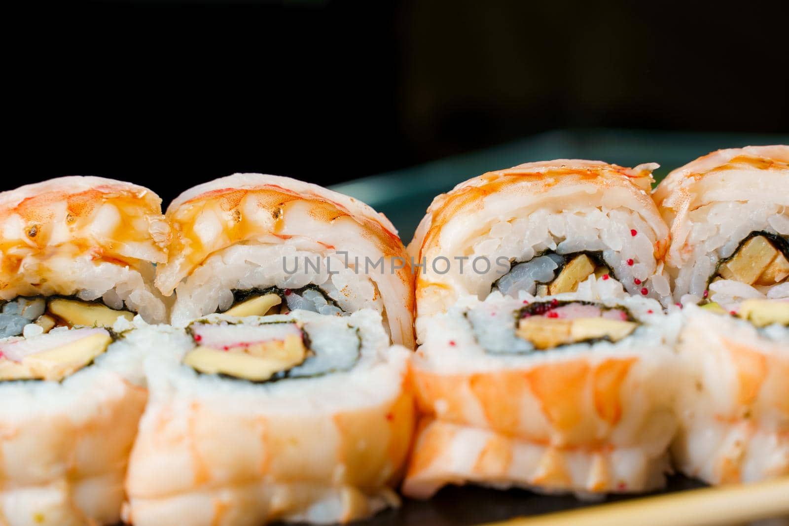 Rolls with shrimp, cheese, and eel, avocado and caviar, nori close-up