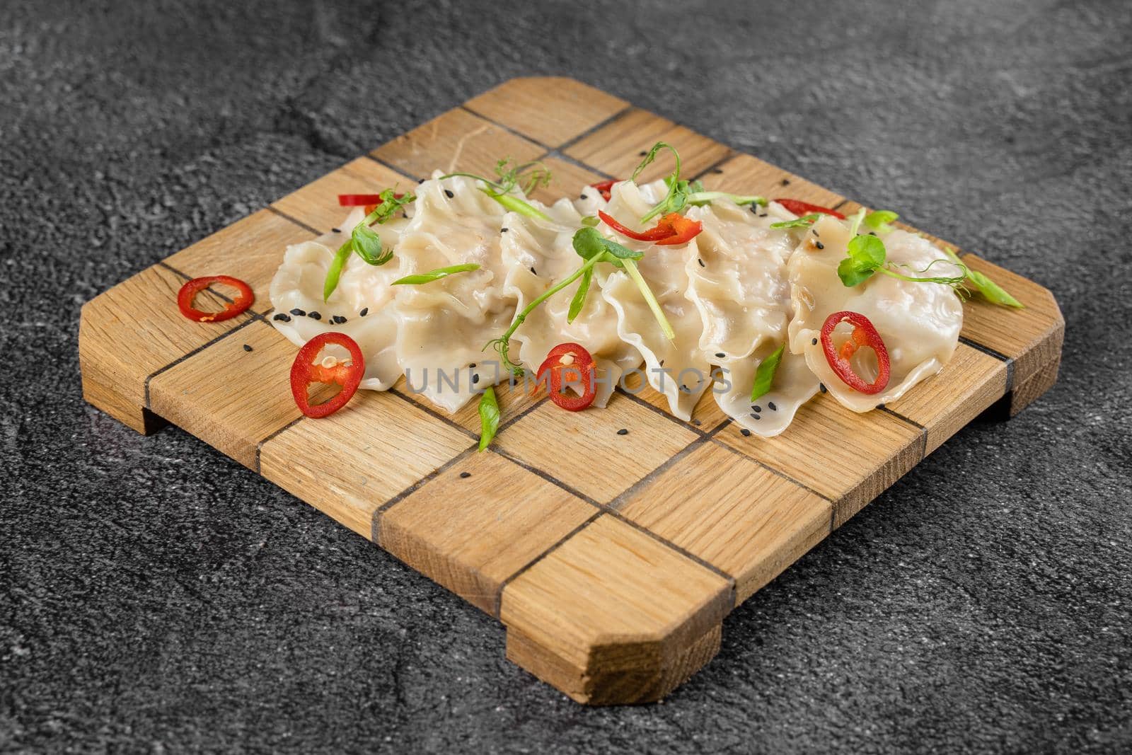 Jiaozi chinese dumplings named gyoza on wooden plate. Asian traditional fast food. Dough dish stuffed with meat and vegetables, less often only meat