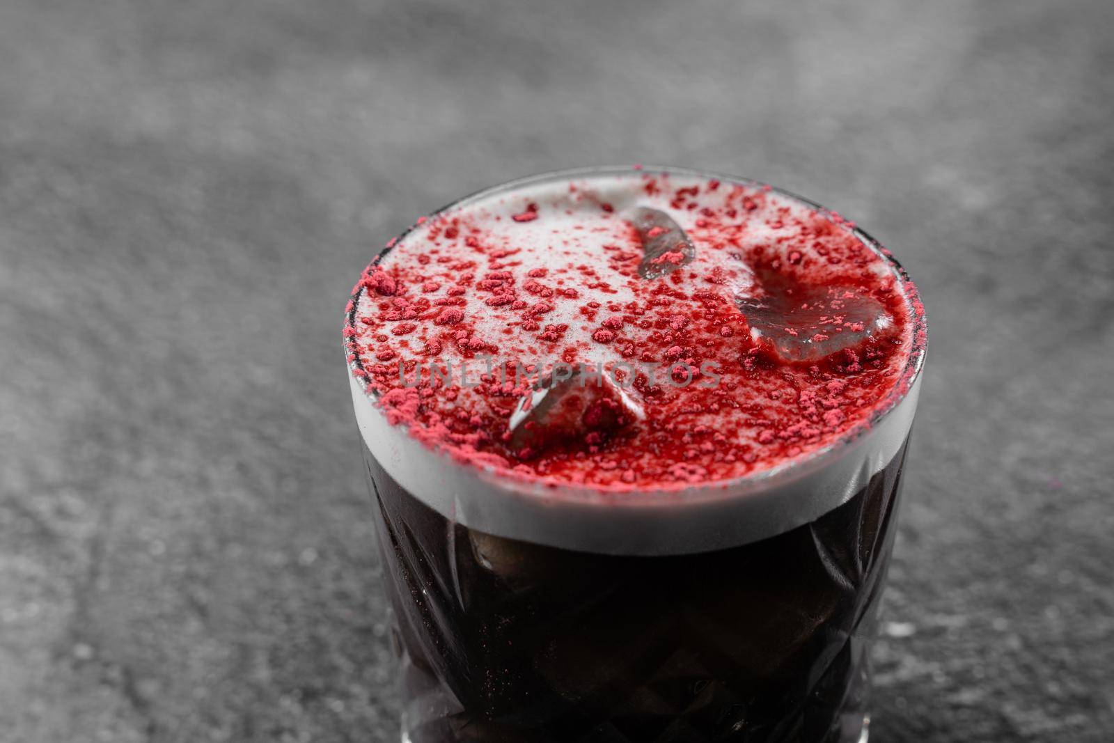 Cocktail with cola, cream, ice, freeze-dried strawberry powder on a gray background. Alcoholic coffee drink