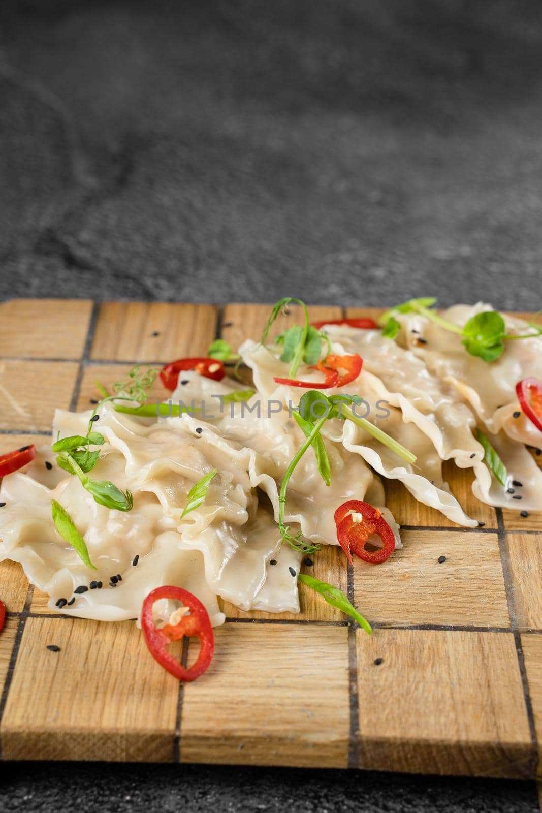 Jiaozi chinese dumplings named gyoza on wooden plate. Asian traditional fast food. Dough dish stuffed with meat and vegetables, less often only meat. by Rabizo