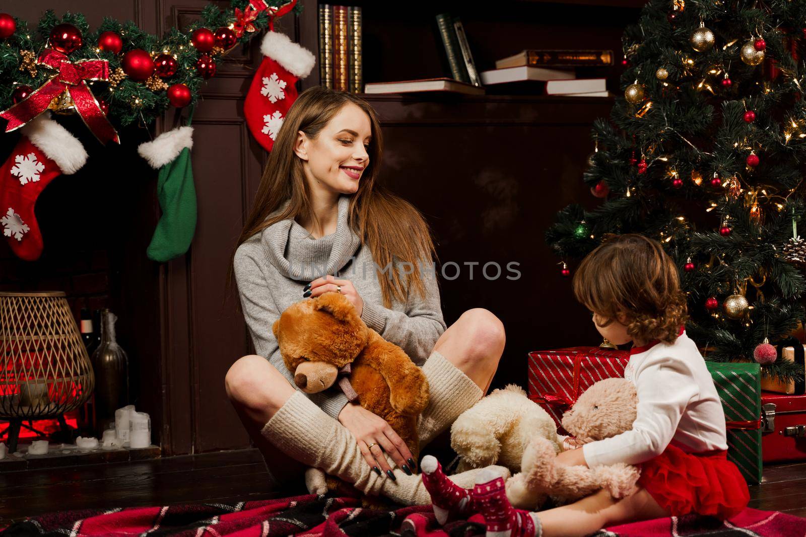 Mother and daughter preparing for christmas celebration. Having fun with family near new year tree. Pregnant woman with daughter