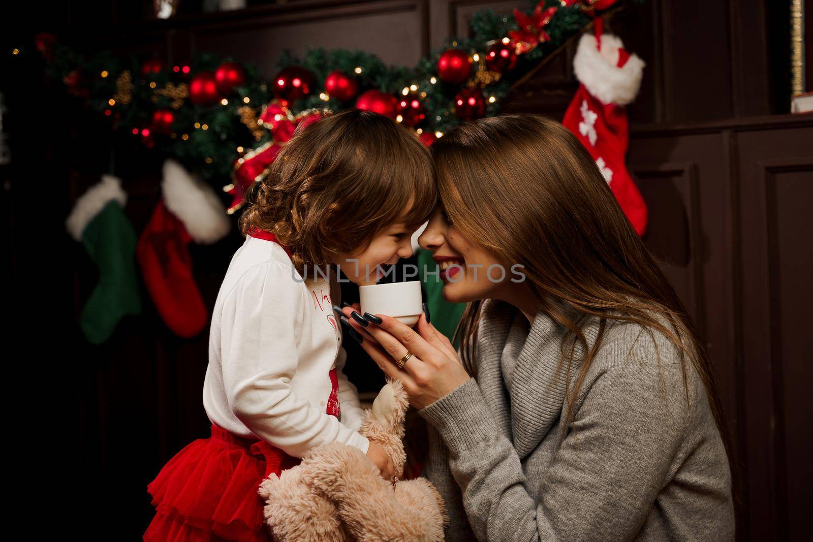 Mother and daughter preparing for christmas celebration. Having fun with family near new year tree. Pregnant woman with daughter. by Rabizo