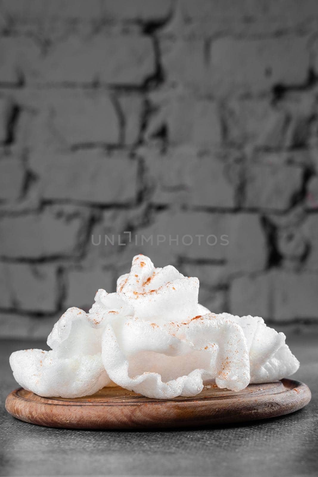 Rice paper chips fried in oil. Rice chips on a wooden board on gray background. by Rabizo