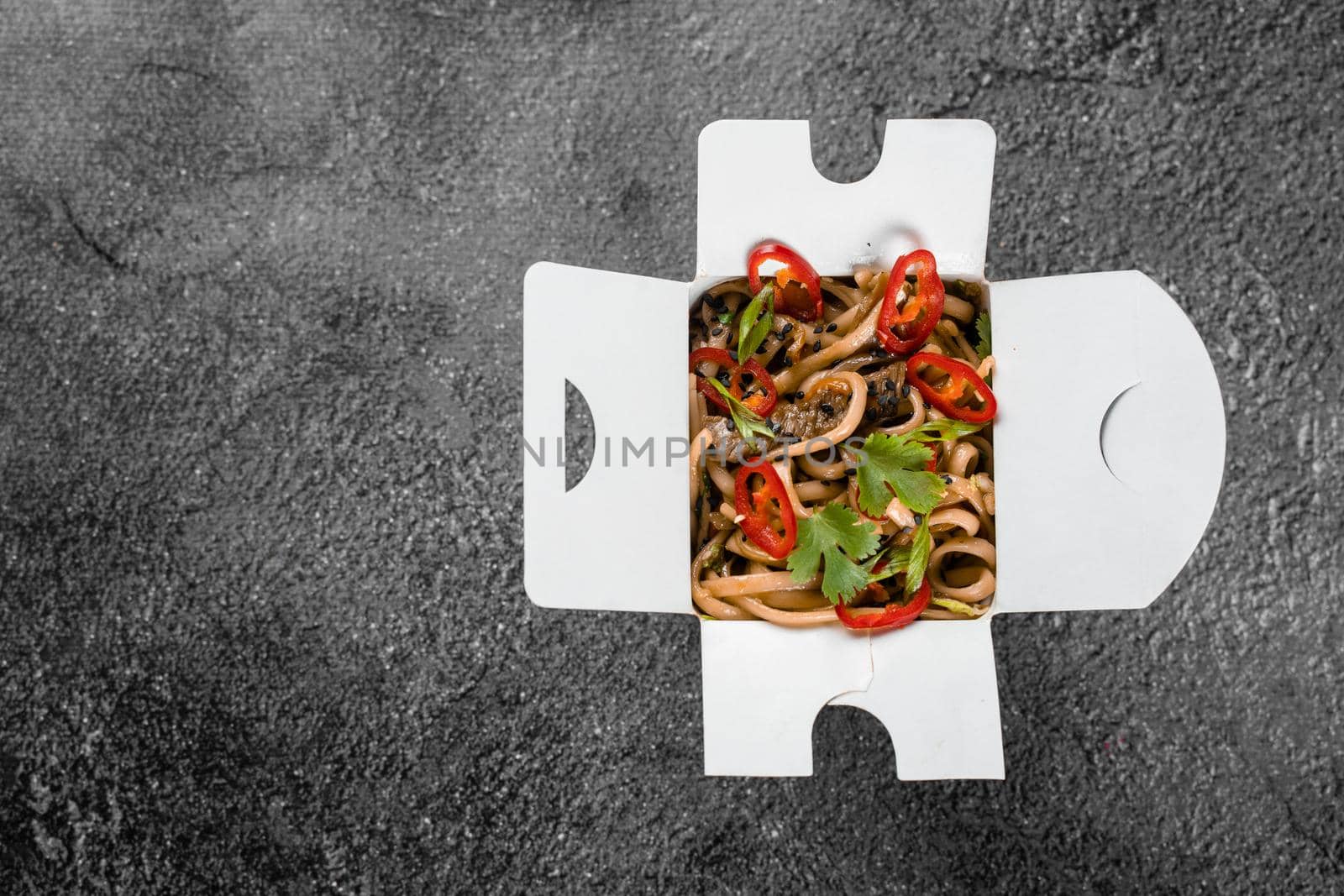 Wok in box spicy noodles in black food container. Fast food delivery service. Takeaway chinese street meal. Top view. by Rabizo